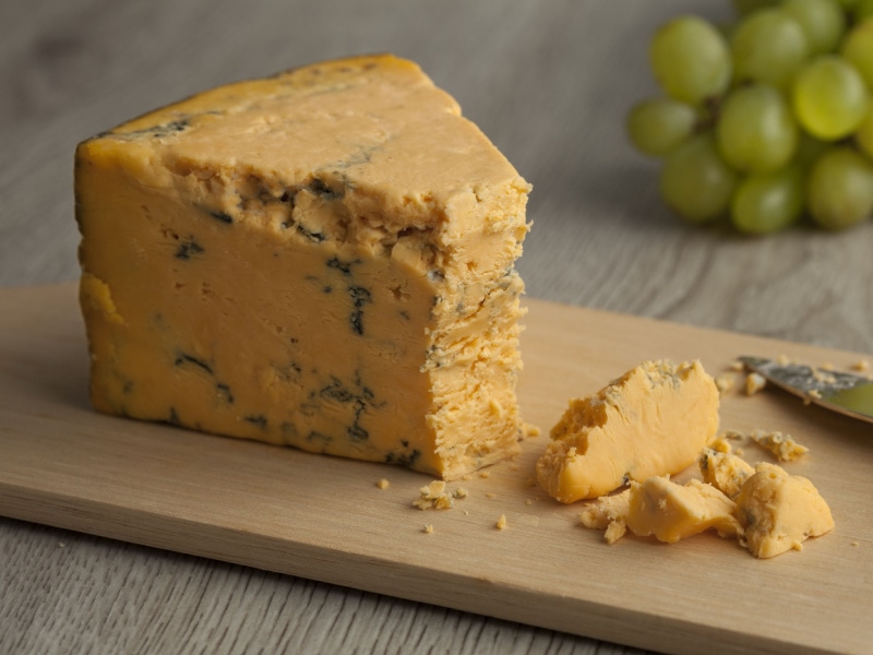 Wedge of English Shropshire Blue Cheese on a Wooden Cutting Board