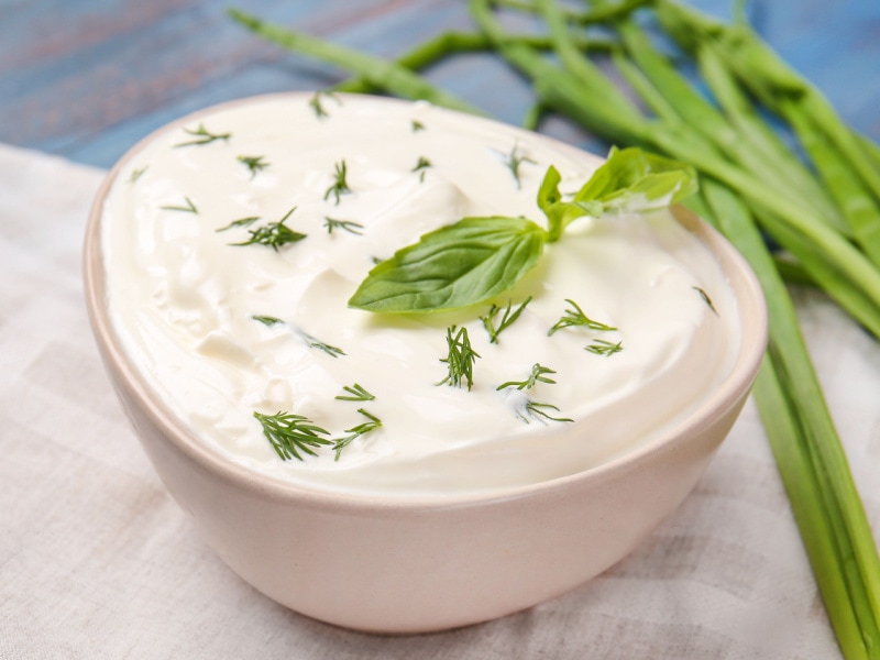 Bowl of Tasty Sour Cream and Green Onion on a Wooden Table