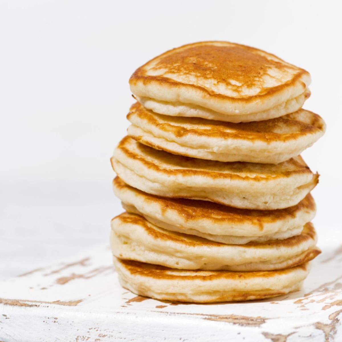 Stack of Fluffy Pancakes on a White and Patina Wooden Board