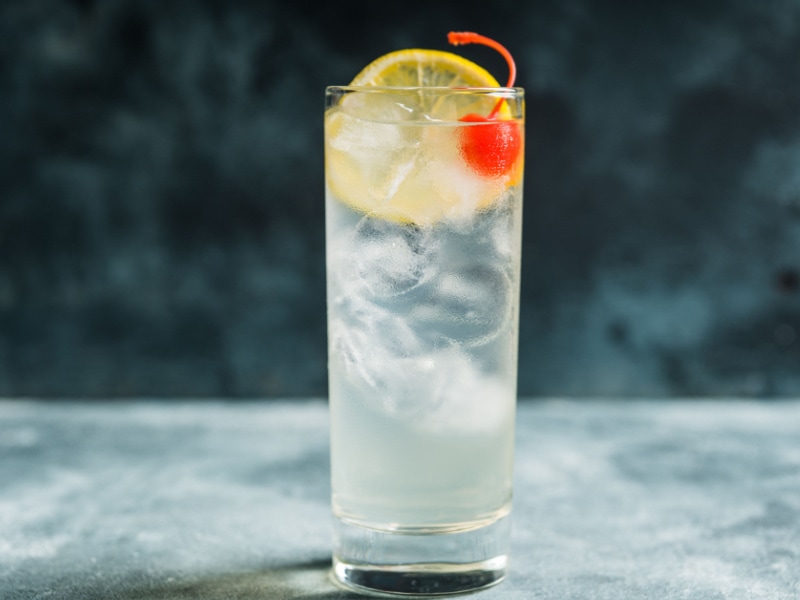 A Tall Glass of Tequila Collins Garnish with  Lemon and Cherry