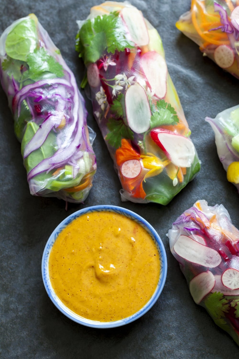 Homemade thai peanut sauce in a bowl with fresh and healthy spring rolls