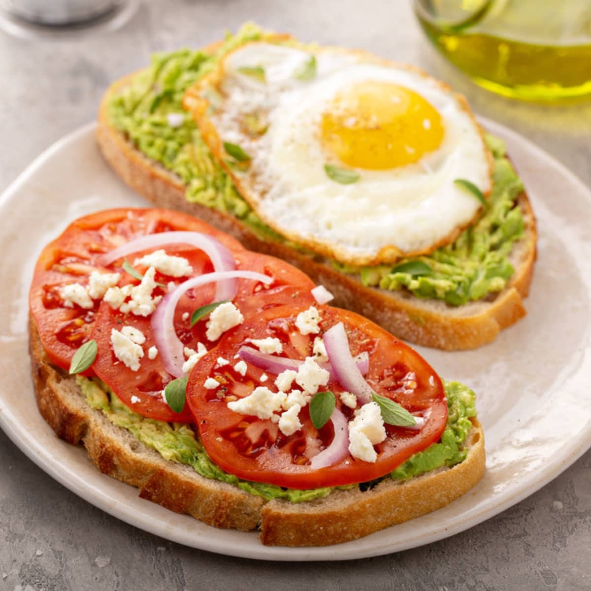 Avocado Toasts For Breakfast With Fried Egg And Heirloom Tomatoes