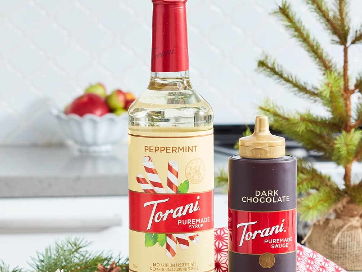 Bottle of Torani Peppermint Syrup and Torani Dark Chocolate Syrup with a Festive Holiday Background
