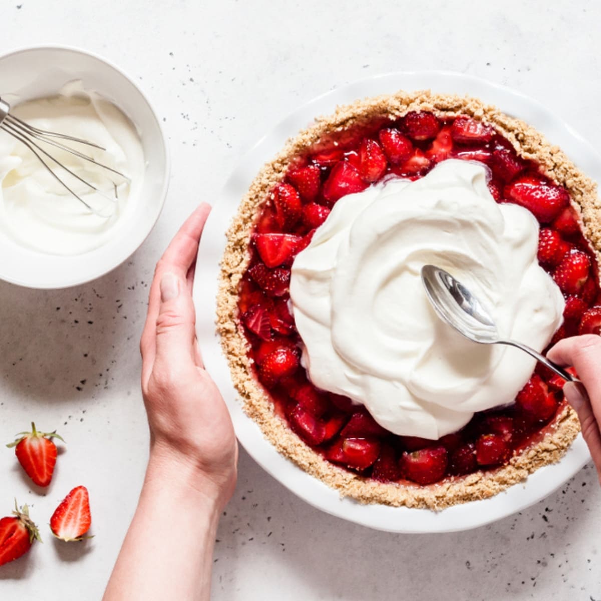 Heavy Cream vs. Heavy Whipping Cream featuring Hands Holding and Spoon Whipped Cream onto Strawberry Pie with a Dish of Whipped Cream to the Side