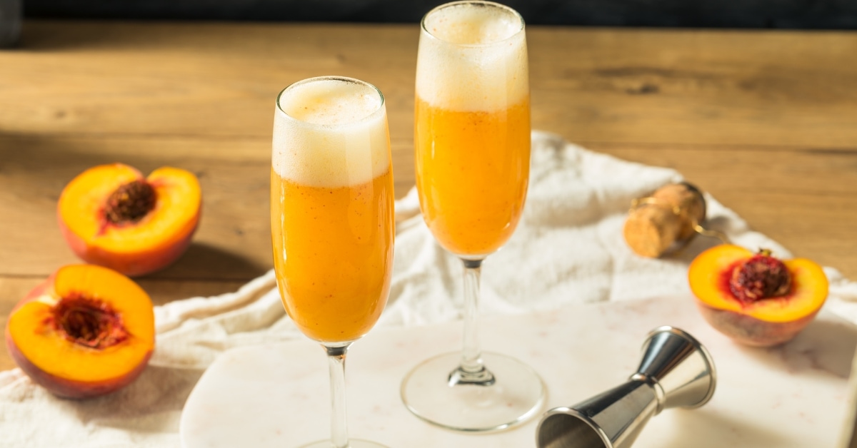 Glasses of bellini with a peach slices, creating a refreshing and vibrant drink.