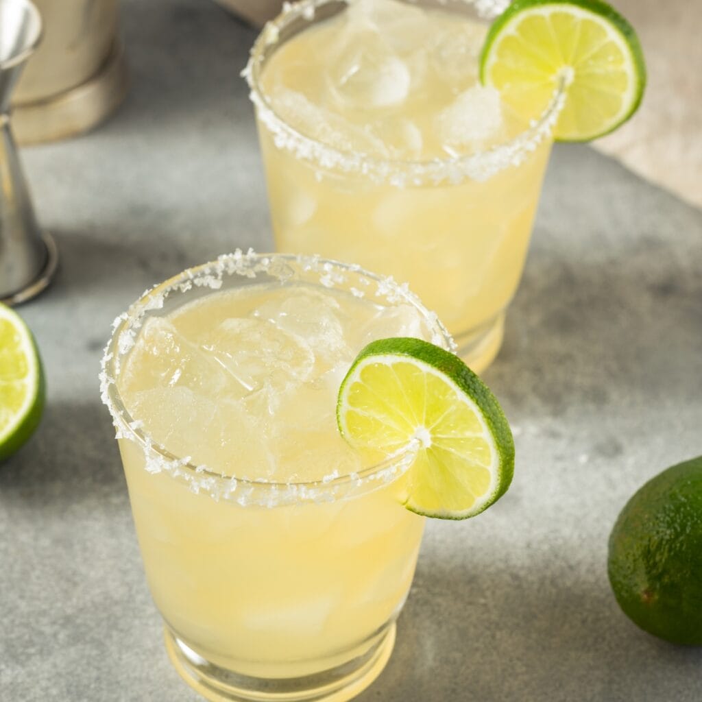 What to Mix with Tequila- 20 Best Mixers featuring Boozy Refreshing Margarita Cocktail with Lime and Tequila with Salt Rim and Lime Wedge Garnishes