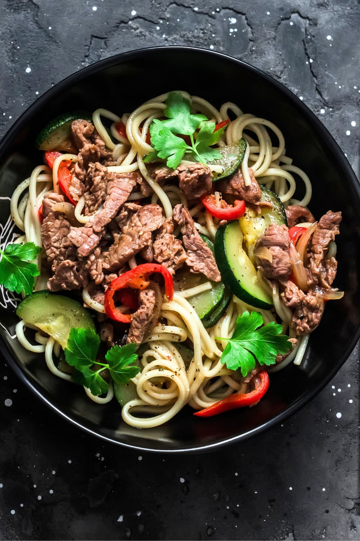 Bowl of Homemade Zucchini Noodles with Beef Steak and Bell Peppers