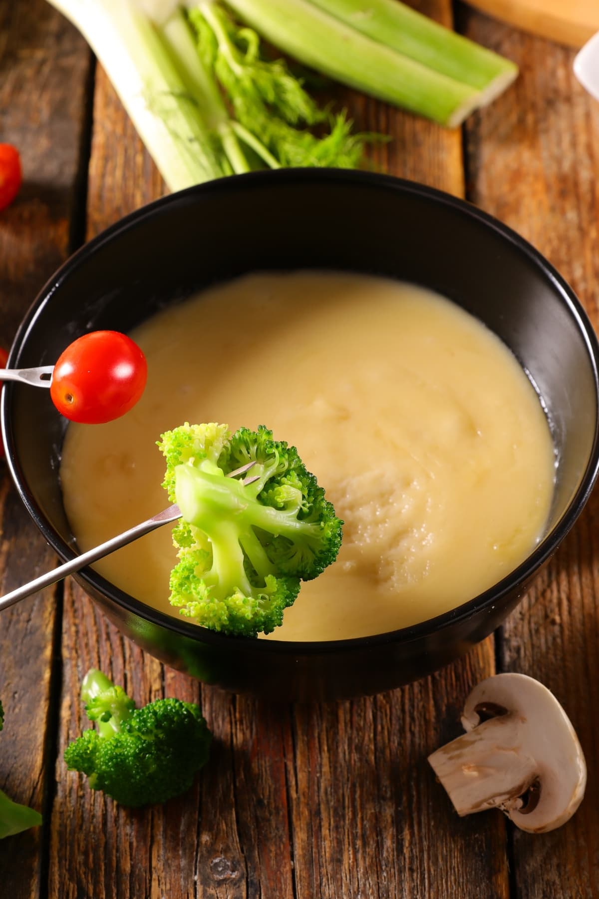 Cheese Fondue in a Black Bowl with Various Vegetables