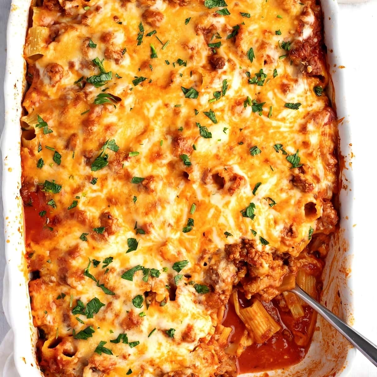Cheesy Baked Rigatoni with Ground Beef in a white casserole dish, top view