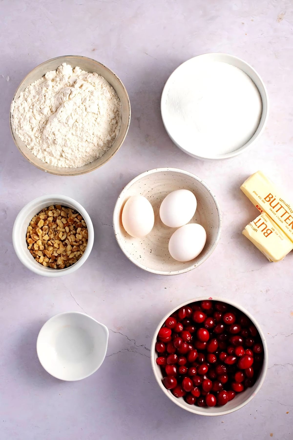 Cranberry Christmas Cake Ingredients - Eggs, Sugar, Butter, Almond Extract, Flour, Cranberries, Chopped Pecans and Whipped Cream