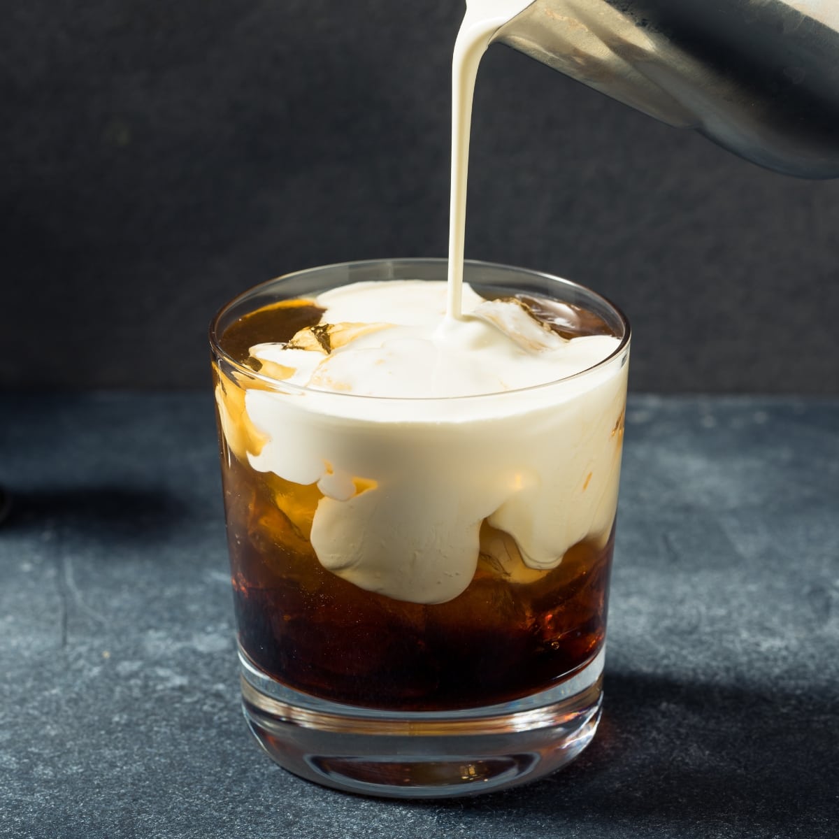Cream Pouring on Vodka To Make a White Russian Cocktail