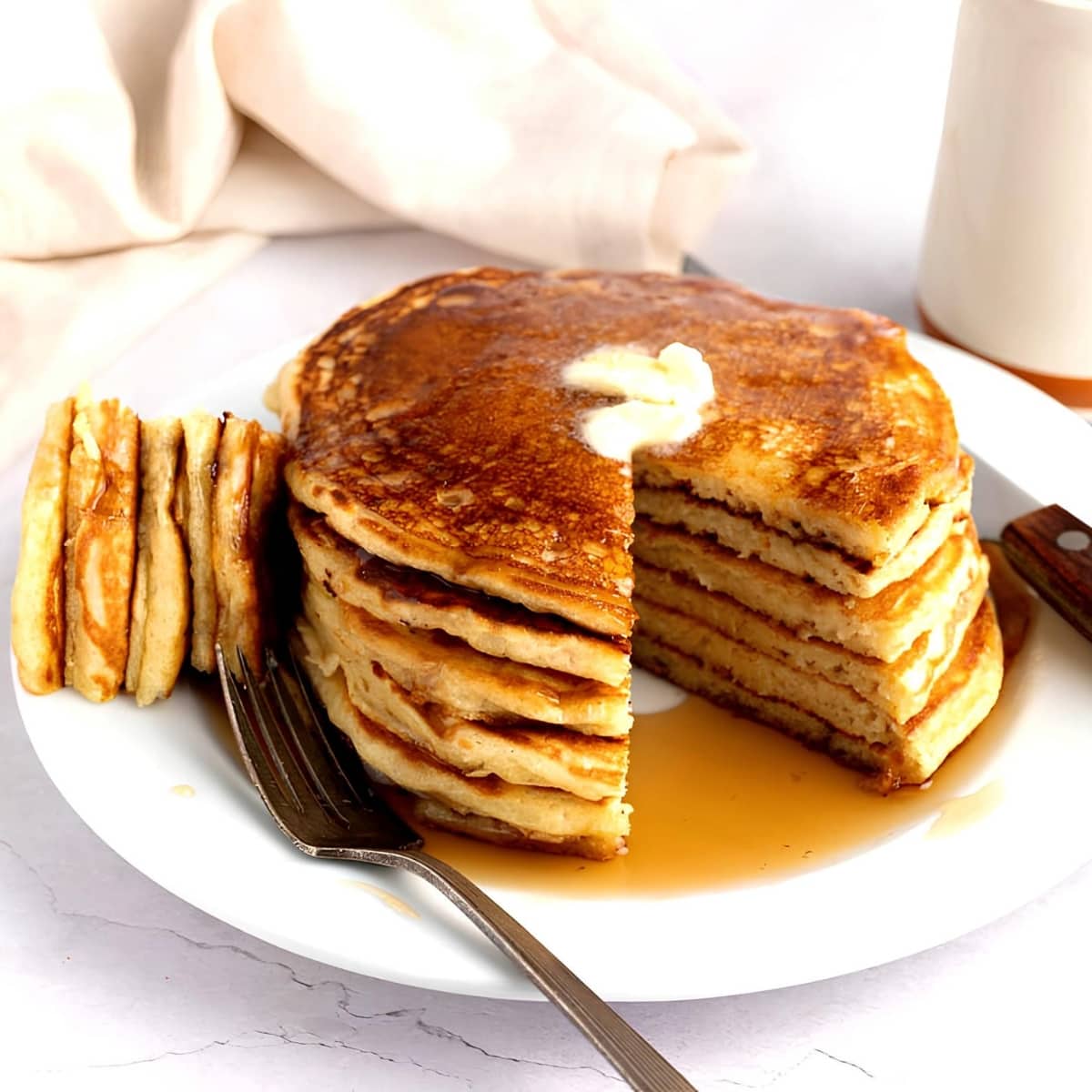 Sliced Fluffy Pancakes Dripping With Maple Syrup and Butter