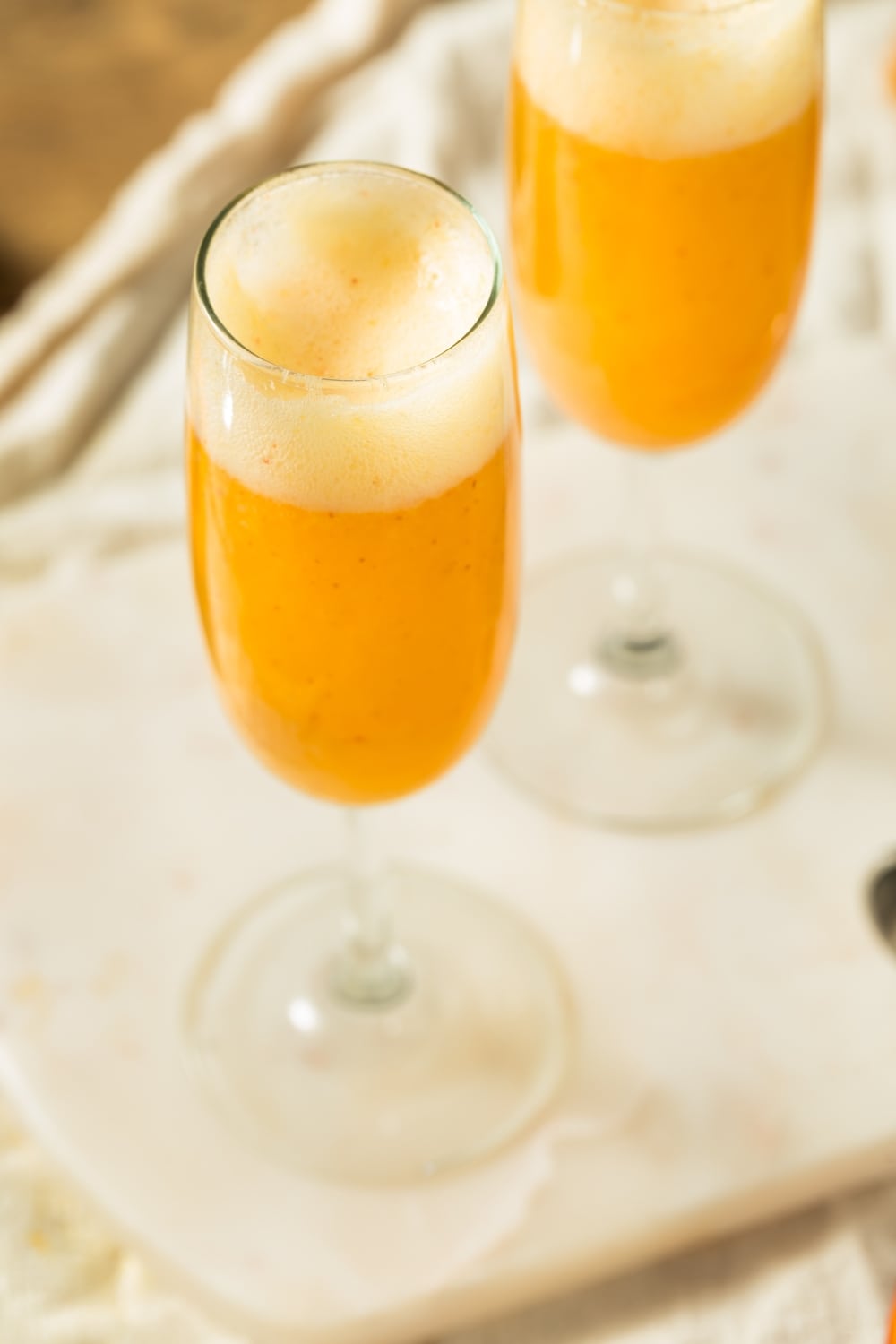 Homemade Bubbly Bellini Cocktails on Wine Glasses