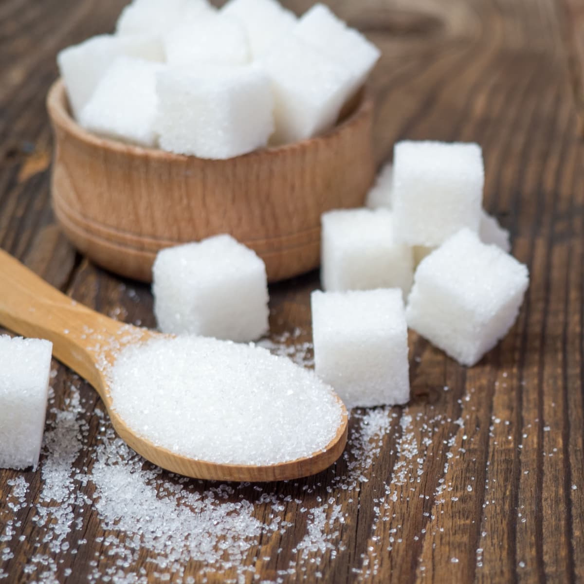 Granulated Sugar Cubes and Powdered Scattered on a Wooden Table