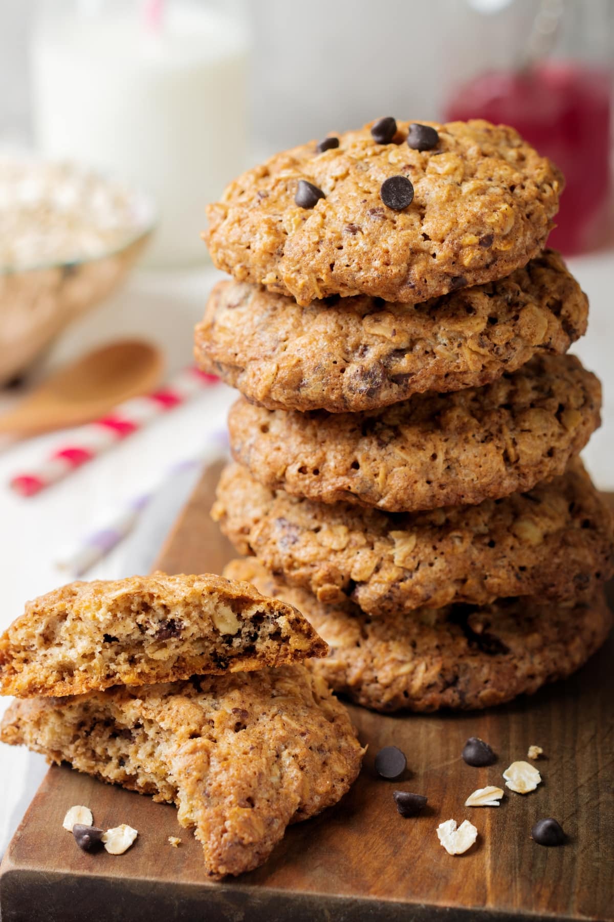 Stack of oatmeal chocolate chip cookies on a wooden cutting board. 