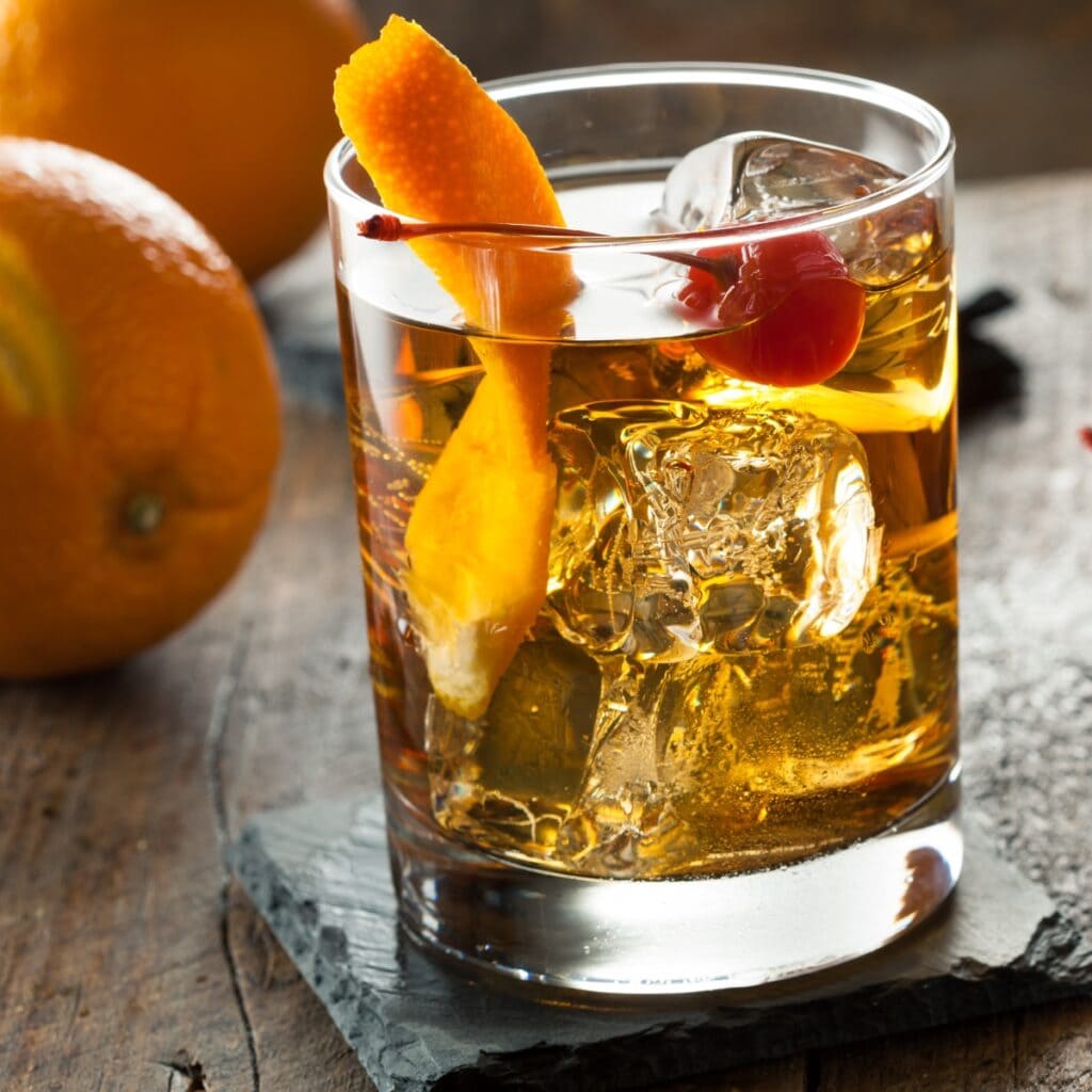 Old Fashion Cocktail Served With Ice, Garnished With Orange Peel and Cherry