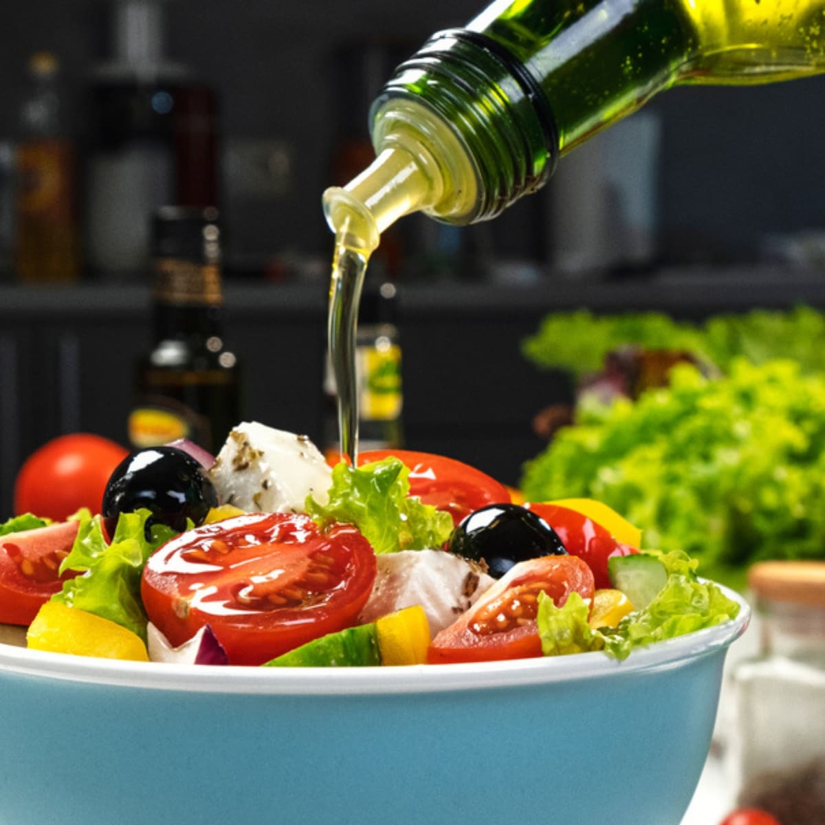 Pouring Olive Oil To a Bowl of Fresh Vegetable Salad
