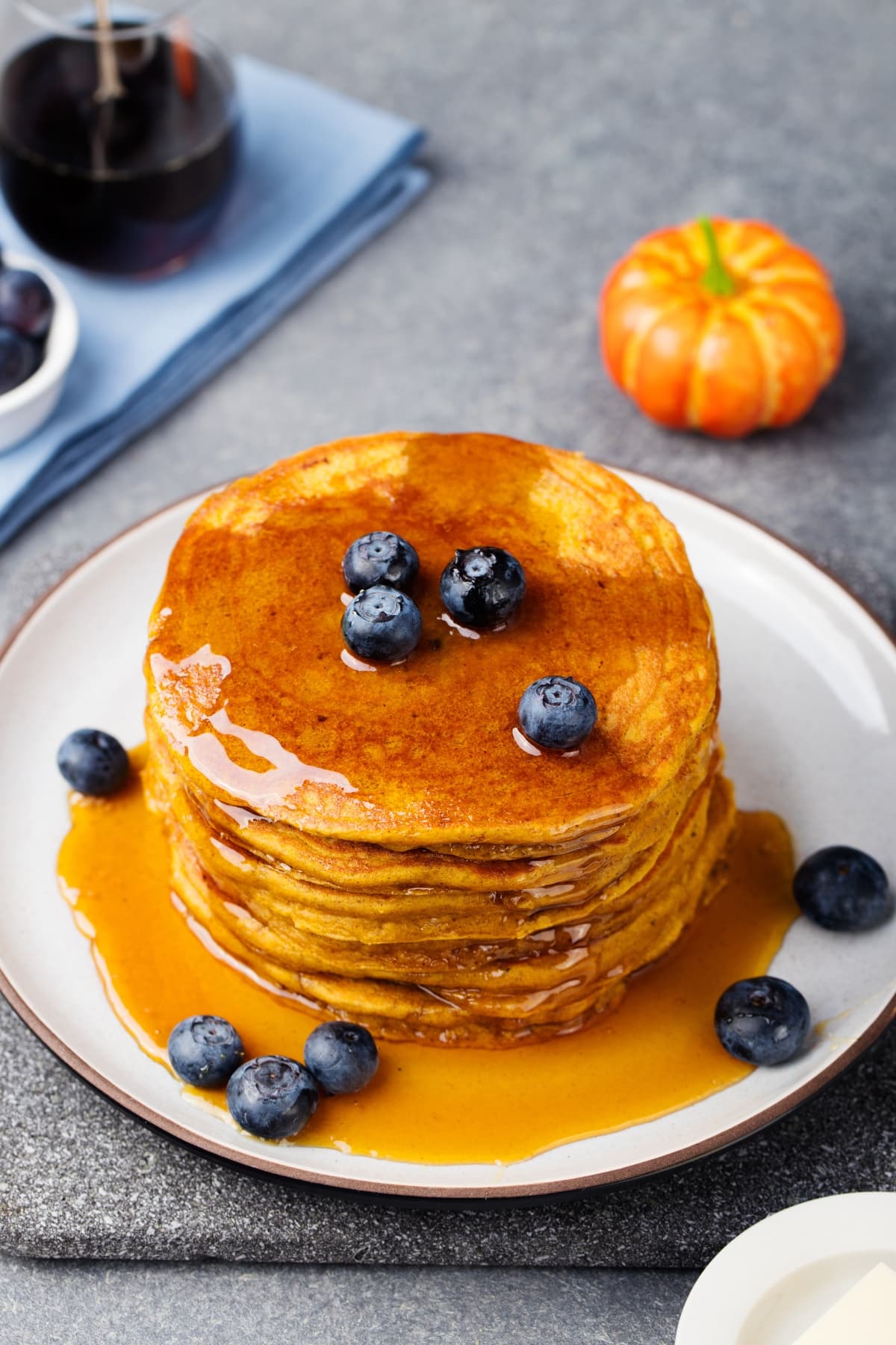 Soft and fluffy pumpkin pancakes with blueberries and syrup