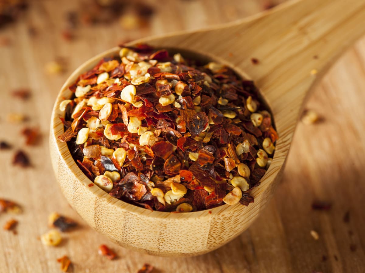 Organic Spicy Red Pepper Flakes in a Wooden Scooper