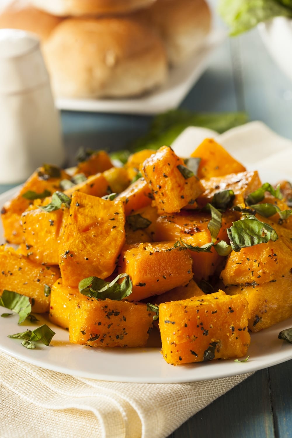 Roasted butternut squash with herbs in a white plate