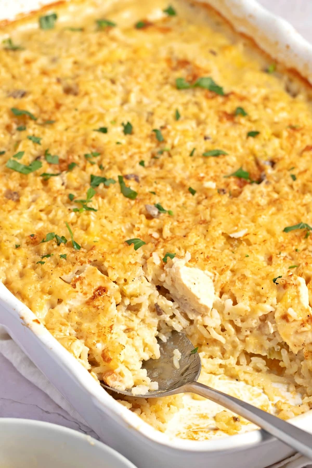 Chicken and rice casserole in a white dish, topped with golden breadcrumbs.