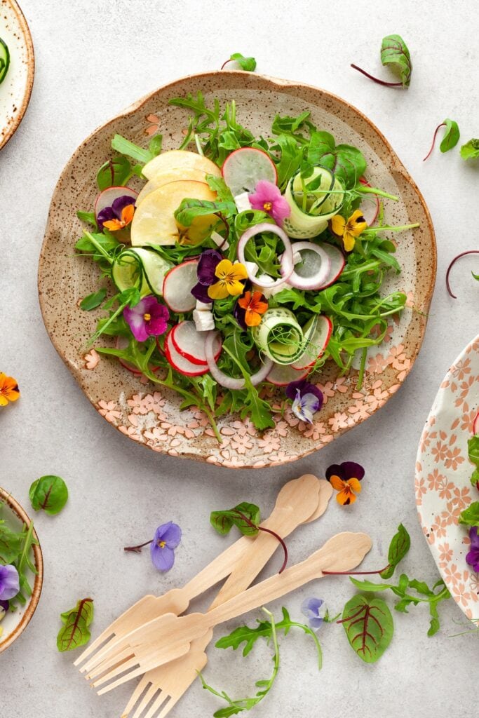 27 Best Microgreens Recipes (Healthy Meals) featuring Summer Salad with Vegetables, Fruits, Microgreens and Cheese in a Large, Flower-Patterned, Ceramic Bowl 