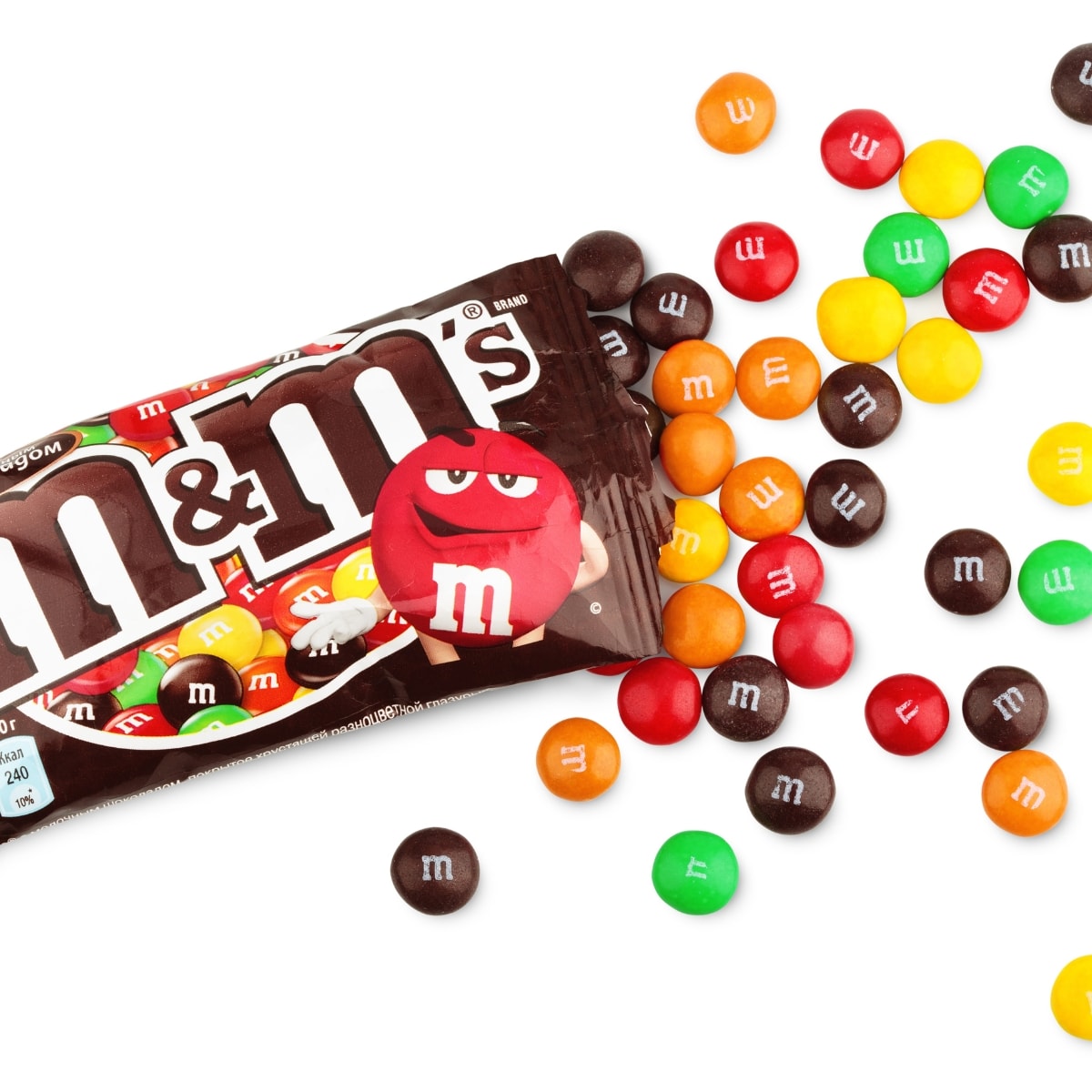 20 Popular M&M Flavors To Try featuring Regular M&M's Chocolate Candies Spilling Out of Brown Packet