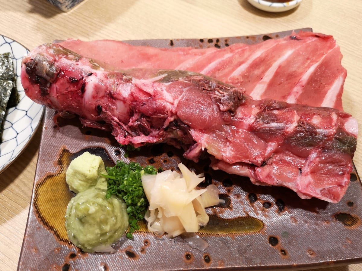Raw Tuna Ribs on a Serving Plate with Oil, Wasabi, Green Onion, and Other Seasonings