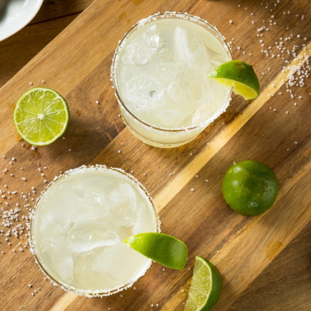 Two Glasses of Iced Maragarita Garnished With Salt and Lime Slice