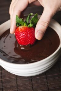 Woman Dipping a Strawberry in a Chocolate Sauce
