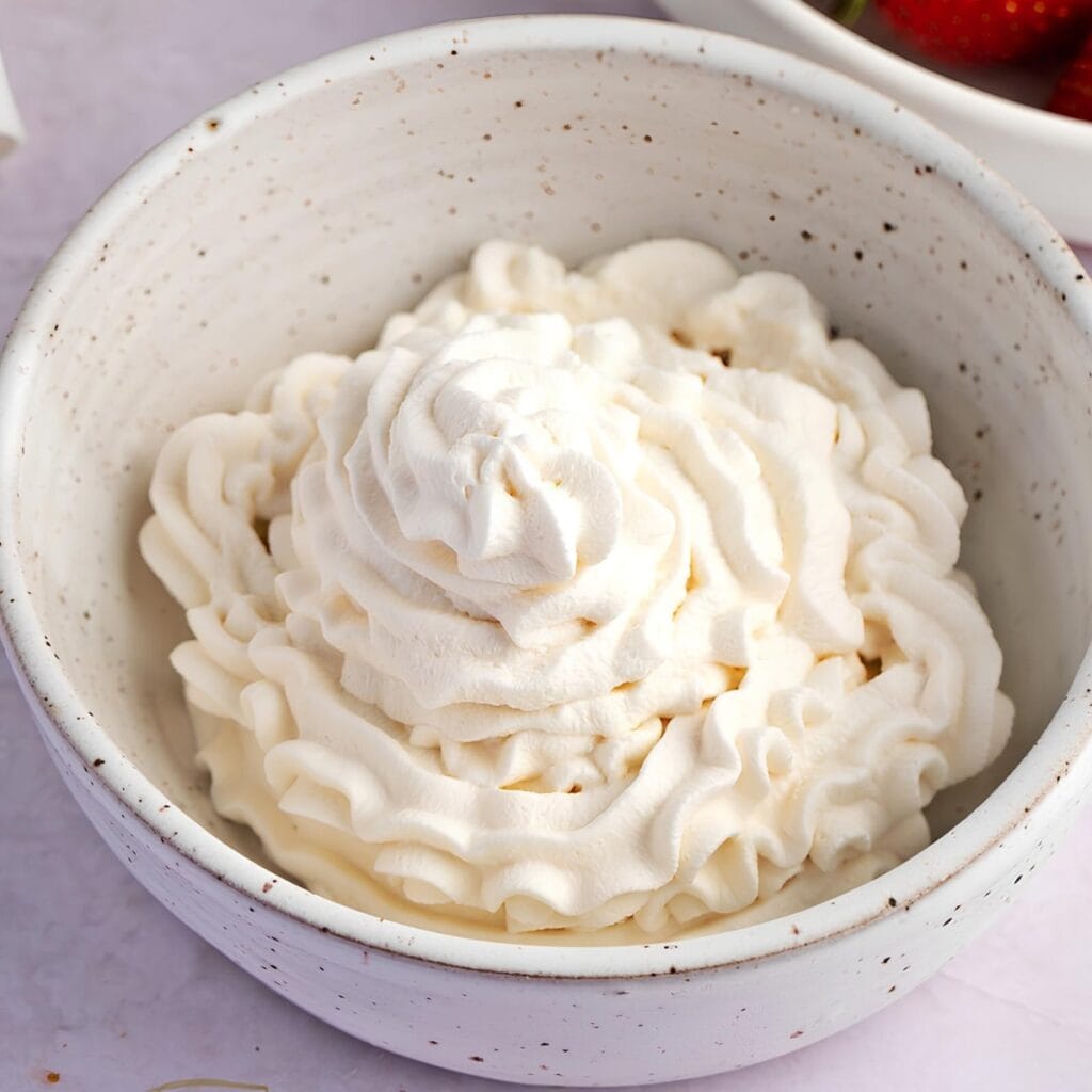 A Bowl of Whipped Cream with Fresh Strawberries