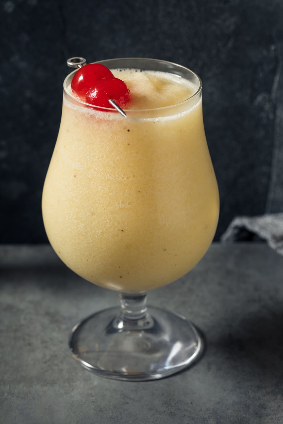 Front View of a Banana Daiquiri in a Tulip Glass with a Cherry on Top