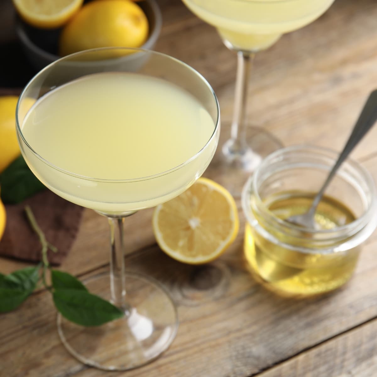 Glass of Refreshing Bee's Knees Cocktail With Lemon and Honey