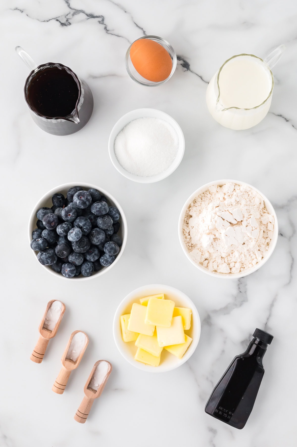 Ingredients for Blueberry Pancakes - flour, baking powder, baking soda, sugar, milk, egg, butter, blueberries, vanilla, salt, maple syrup