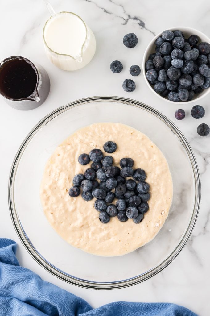 Pancake batter with blueberries in a glass bowl.