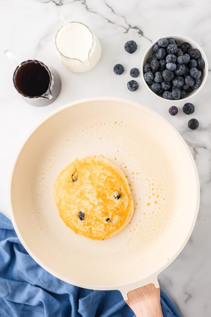 Freshly cooked blueberry pancake in a skillet.