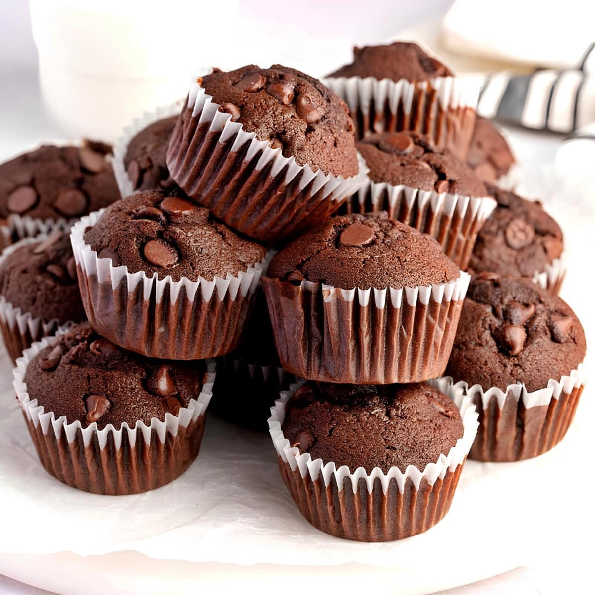 Bunch of Chocolate Muffins on a Round  Plate with Parchment Paper
