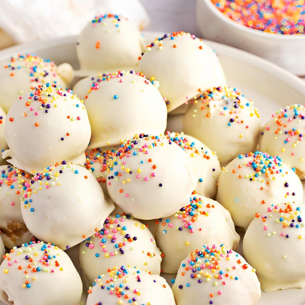 Bunch of White Cake Balls Covered Rainbow Sprinkles