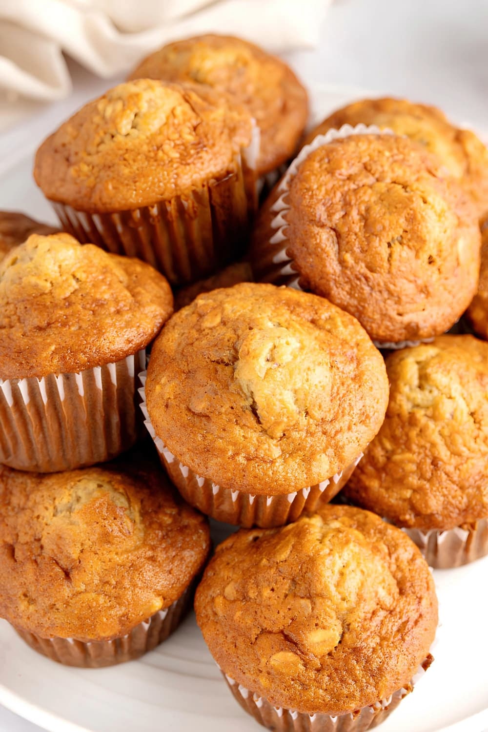Bunch of banana oat muffins on a white table. 