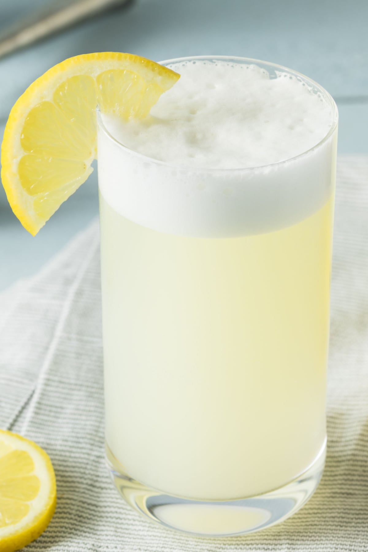 Close up shot of a glass of gin fizz cocktail garnish with lemon slice