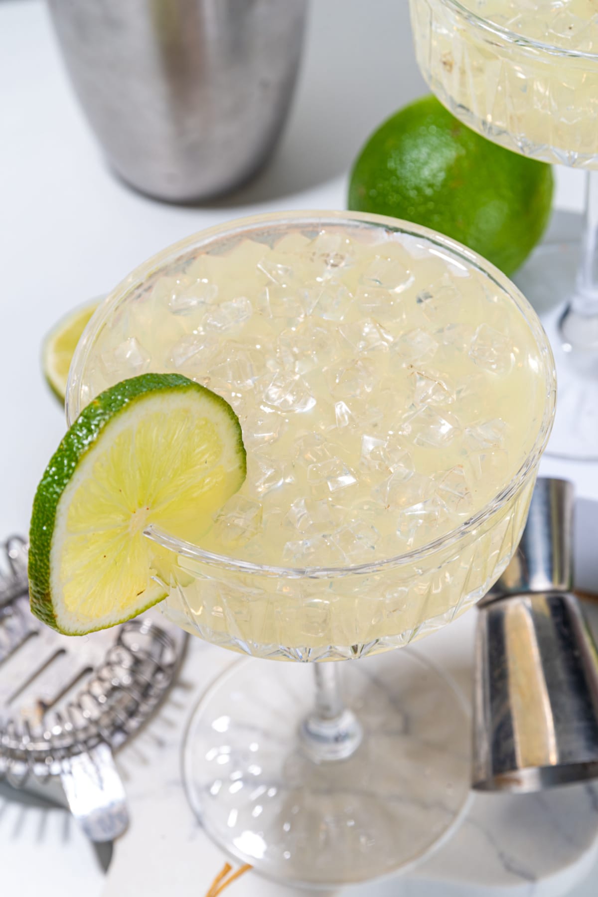 A refreshing glass of gimlet cocktail, filled to the brim with tangy citrus flavors and garnished with lemon wheel on the rim