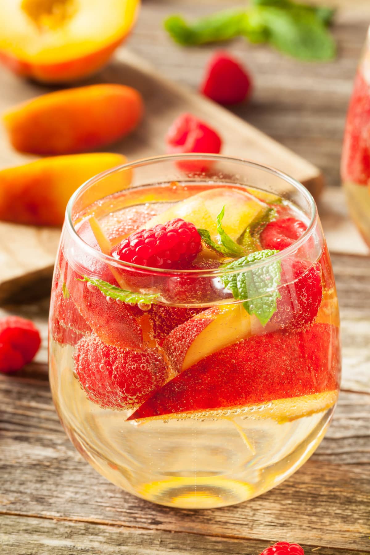 Fresh peaches and raspberries on a glass of wine sangria