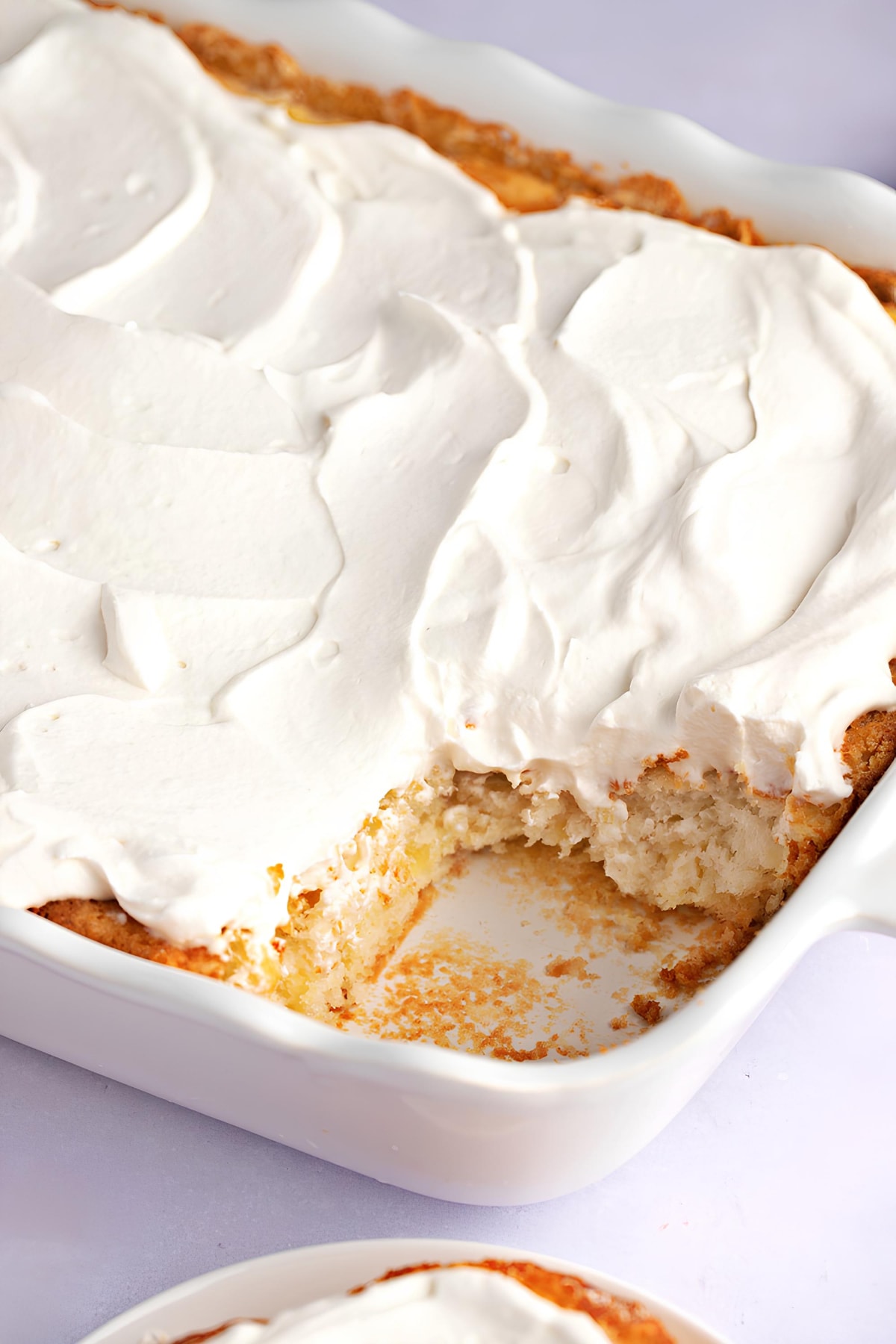 Homemade Pineapple Angel Food Cake with Whipped Cream in a White Casserole