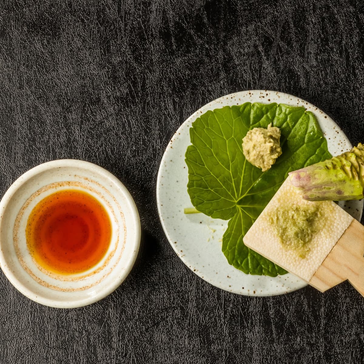 Japanese Wasabi Root and Paste with Grinder on a Bowl with Bowl of Sauce to  the Side