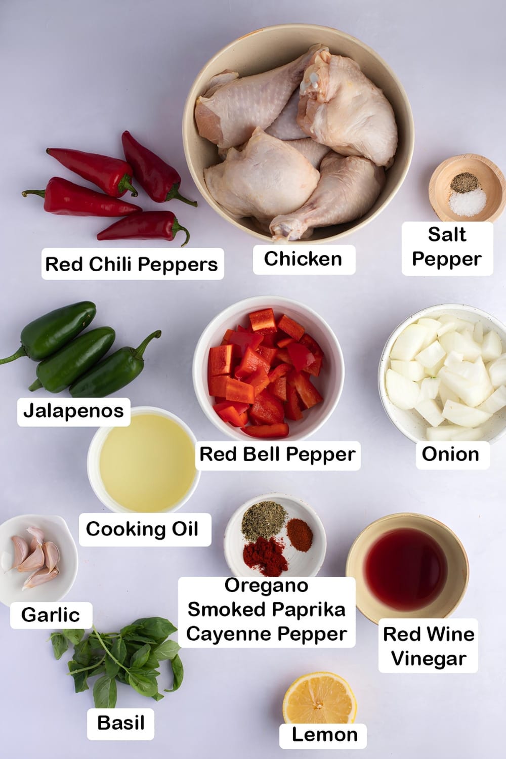 Peri-Peri Chicken Ingredients, red chili peppers, chicken, salt, pepper, jalapenos. red bell pepper, onion, cooking oil, garlic, smoked paprika, oregano. cayenne pepper, red wine vinegar, basil and lemon