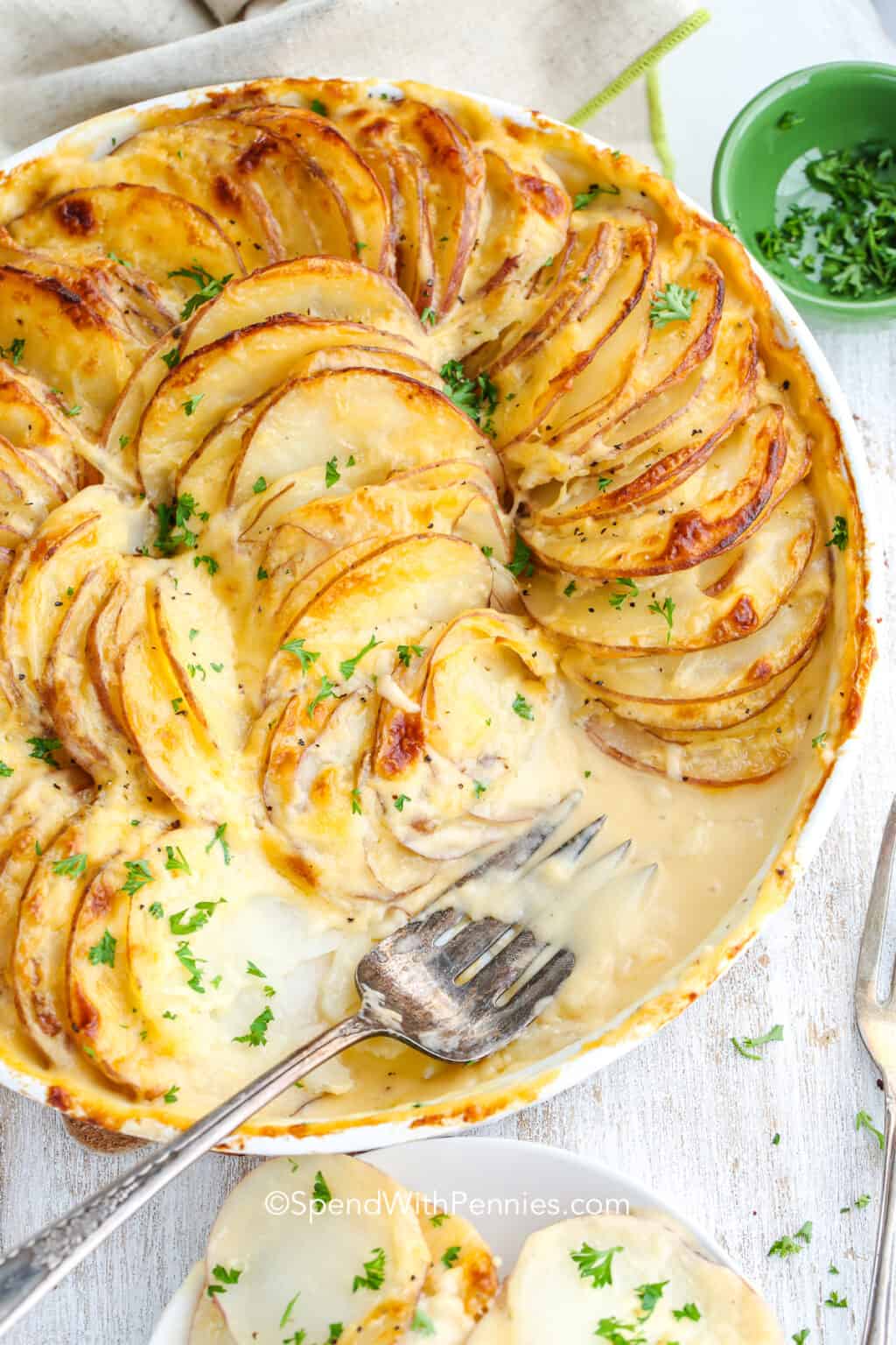 Potato au gratin topped with melted cheese and garnished with fresh parsley