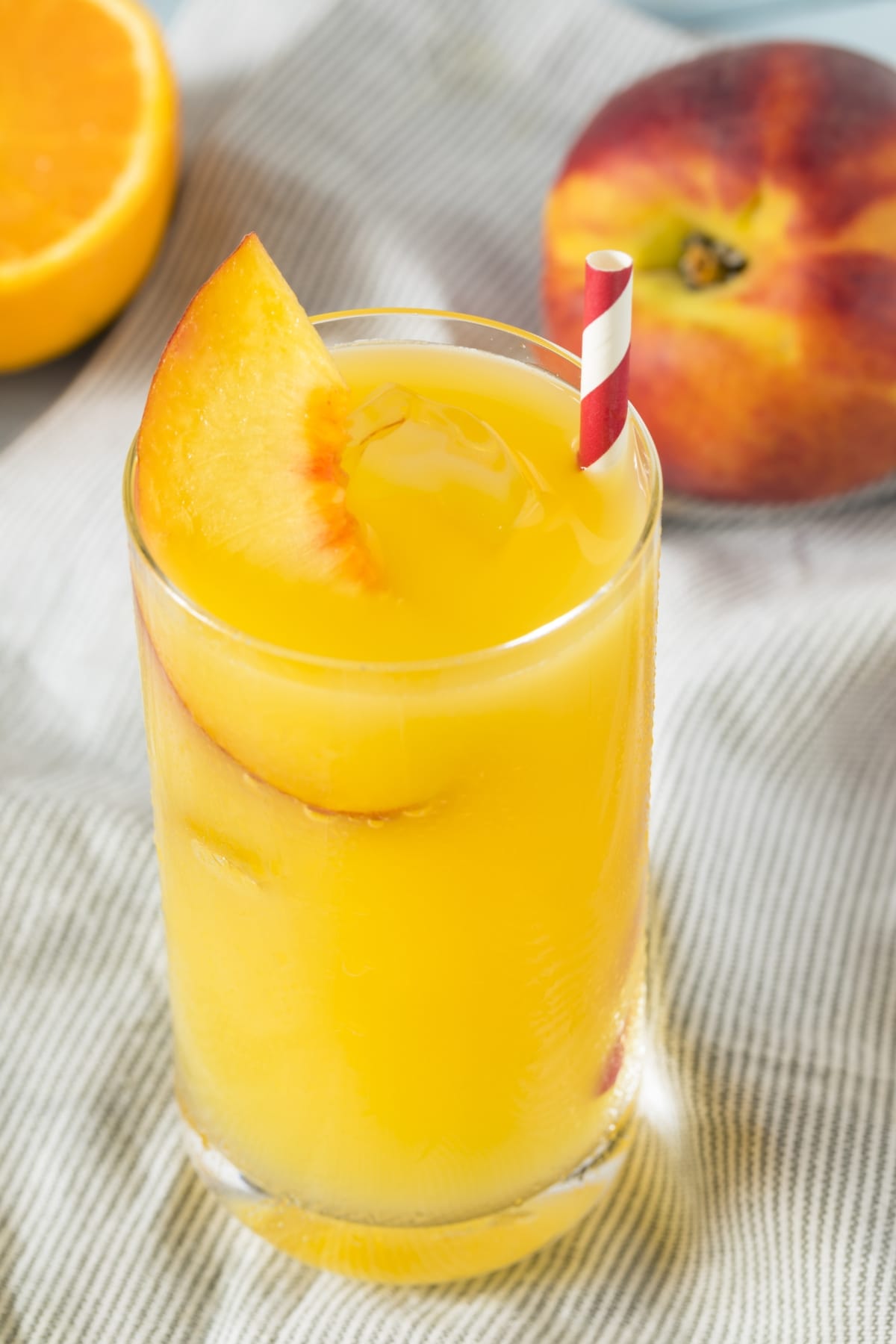 Refreshing Fuzzy Navel Cocktail Garnished With Slice of Peach