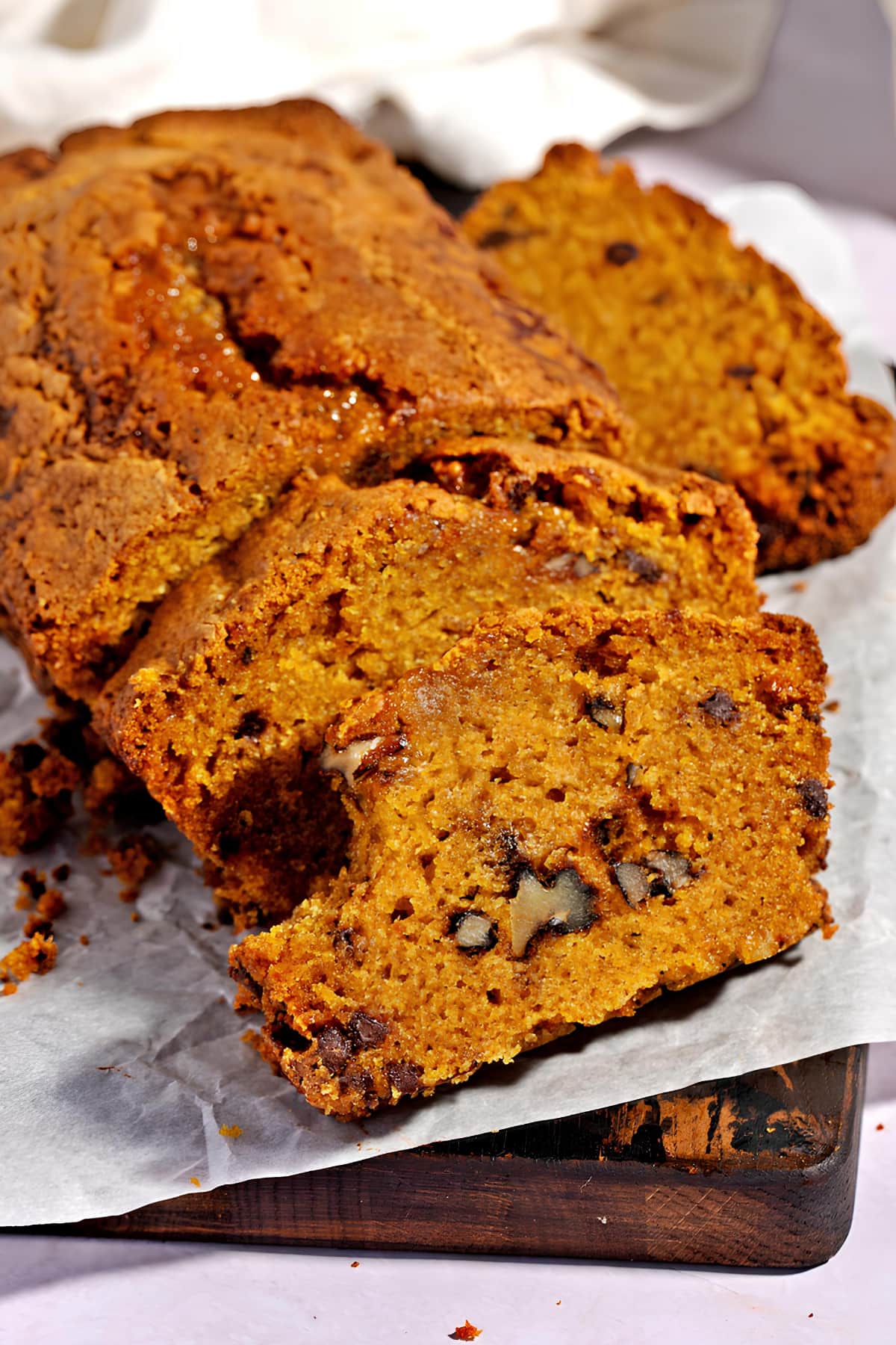 Sliced Chocolate Chip Pumpkin loaf bread on a parchment paper. 