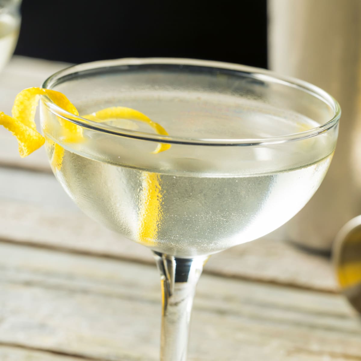 Close up shot of a glass of vesper martini garnished with lemon peel 
