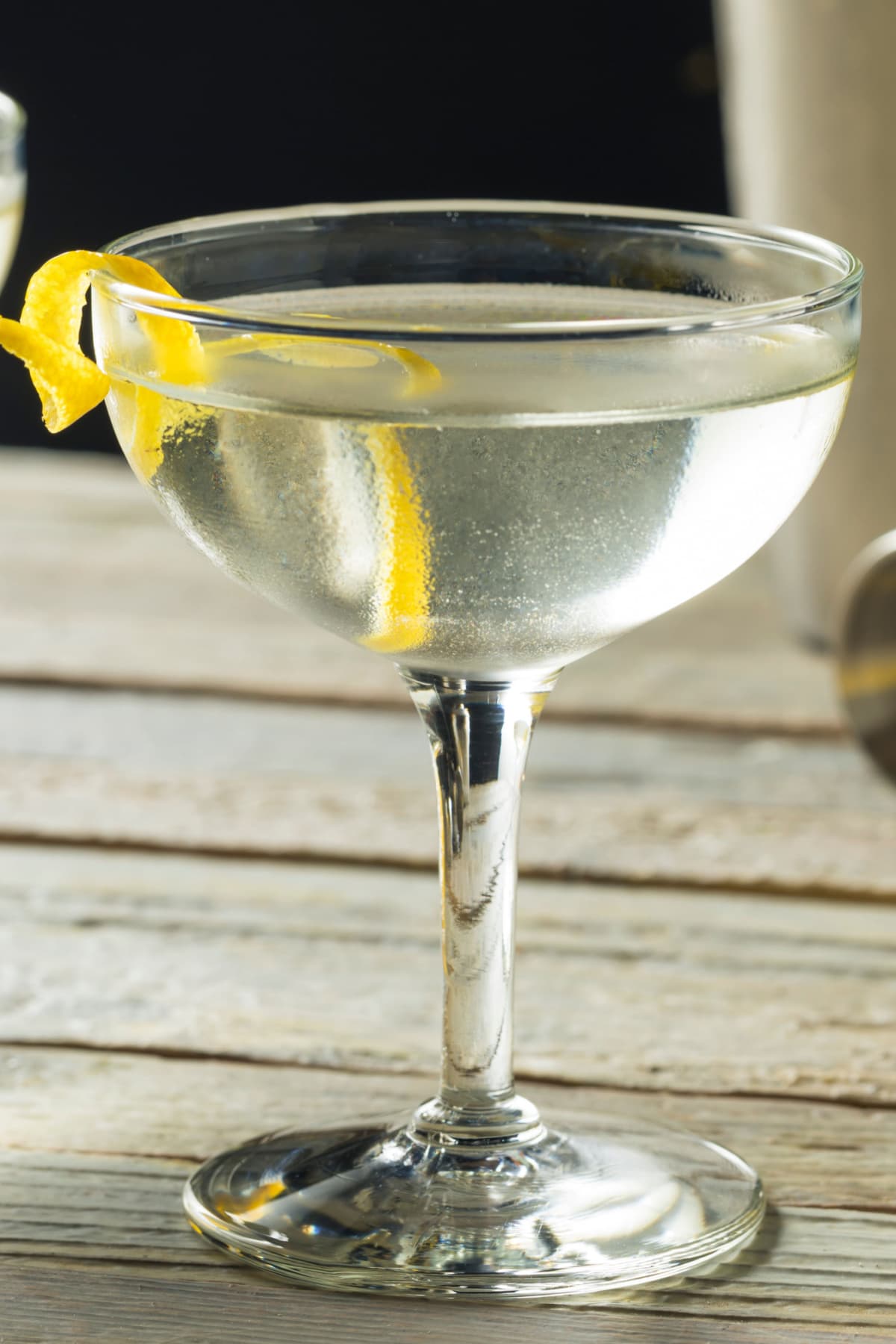 A glass of Vespa Martini on a champagne coupe garnished with lemon peel